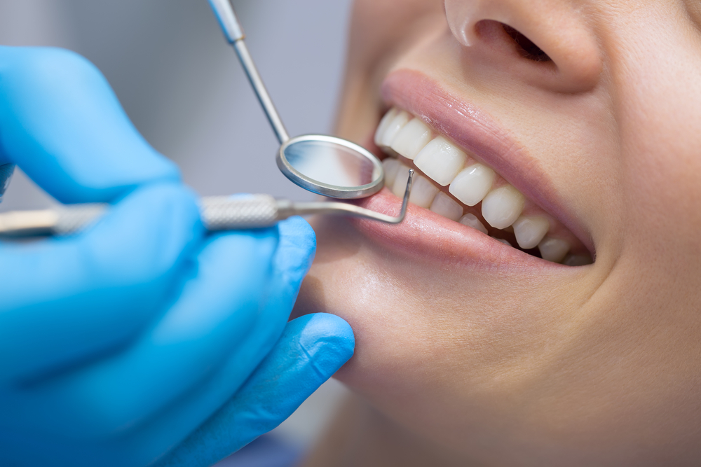 Dentist examining a patients teeth in the dentist